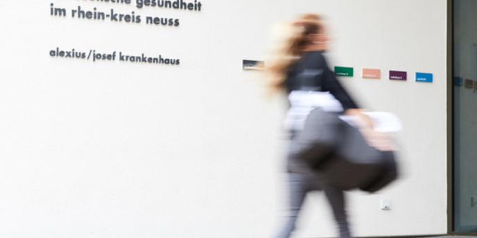 Eine Patientin kommt zu ihrer stationären Aufnahme ins Alexius/Josef Krankenhaus, nachdem das zentrale Belegungsmanagement die dafür notwendigen Schritte eingeleitet hat