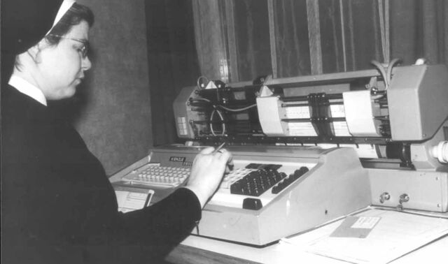Ein historisches Bild einer Nonne, die etwas auf einer Schreibmaschine tippt.